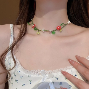 Détail du collier ras du cou perlé avec fleurs colorées et cordon vert style vigne
