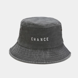 Close-up of white CHANCE embroidery and metal eyelets on vintage dark grey bucket hat