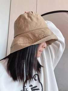 Side view of a khaki cotton bucket hat with fine stitching on a female model