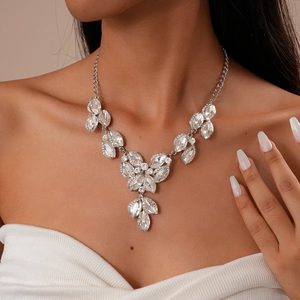 Detail of silver marquise-cut crystal leaf necklace set on model for evening wear