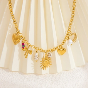 Detail of 18k gold plated necklace featuring sun pendant, shell and pearl accents