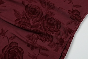 Macro detail of wine red velvet rose pattern on semi-transparent mesh fabric