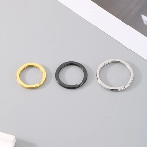 Close-up view of three stainless steel split key rings in gold, black, and silver finishes.