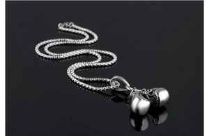Macro view of silver boxing glove pendant with reflective finish on black background