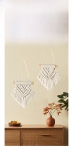 Detailed close-up of handmade boho macrame wall hanging with cotton fringe and wood