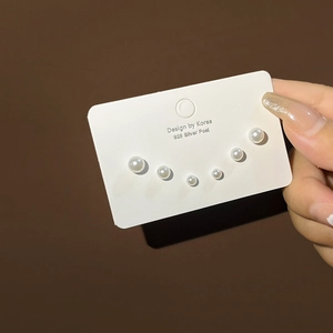 Close-up of three pairs of 925 silver pearl stud earrings in varying sizes on a card
