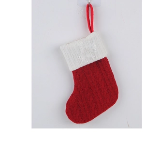 Close-up of red knitted Christmas stocking with white cuff and cable knit pattern detail