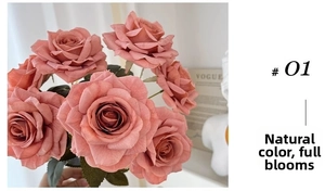 Detail of coral pink artificial roses with realistic petals and deep green leaves