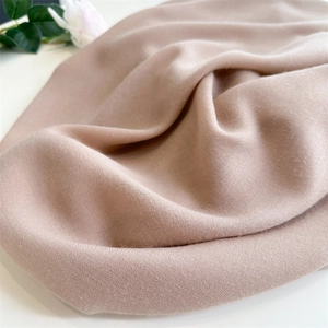 Close-up of beige linen cotton scarf texture with soft folds and elegant rose detail