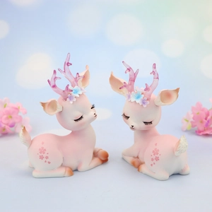 Close-up of pink Nordic resin deer ornaments with delicate floral details and cherry blossoms