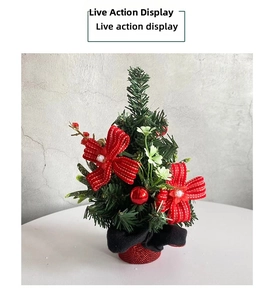 Mini Christmas tree with red polka dot bows and glossy ornaments on a white table
