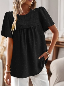 Close-up of black short sleeve top featuring 3D dot texture and lace patchwork detail