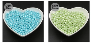 Detailed view of light blue and light green no-hole imitation pearls in heart-shaped bowls