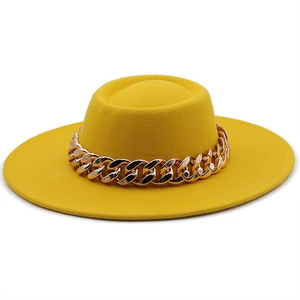 Detailed view of the yellow wool felt wide brim hat with a chunky decorative gold chain