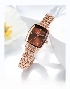Detail of Gedi rose gold rectangular watch with diamond bezel next to white porcelain