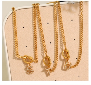 Detail der goldenen Gliederkette mit funkelnden S-, T- und U-Anhängern mit Steinbesatz