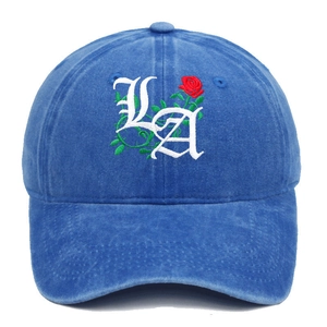 Detail of gothic LA embroidery and red rose on washed blue cotton baseball cap