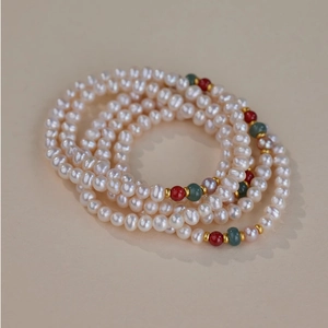 Close-up of freshwater pearls and agate stone beads in a multi-layer elegant bracelet