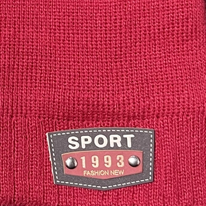 Red knit winter beanie for men and women featuring a sport fashion shield patch and rivets