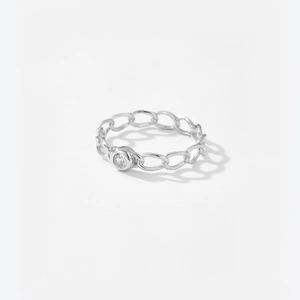 Macro shot of silver chain-style ring band with a sparkling central round zircon stone