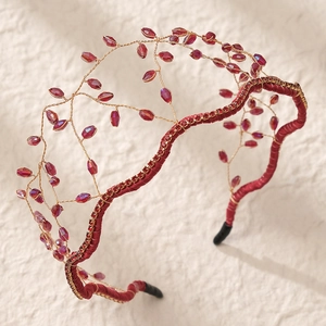 Detailed view of handmade bridal headband with red faceted beads and gold wire weaving