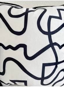Detail of velvet throw pillow cover featuring modern black abstract curved lines