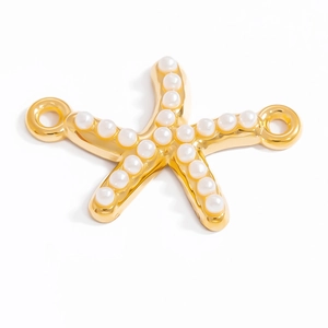 Détail macro du pendentif étoile de mer doré 18 carats avec perles blanches incrustées
