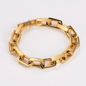 Detail shot showing the polished golden link chain bracelet with square buckle design