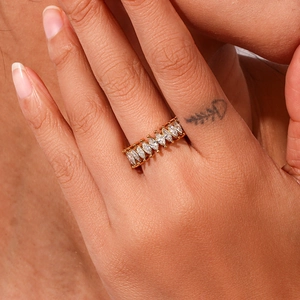 Detailed close-up of a golden marquise-cut zircon eternity band worn on a finger