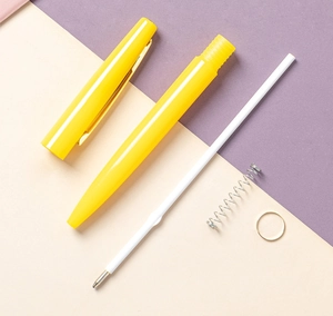 Composants d'un stylo bille jaune démonté montrant la recharge et le ressort interne
