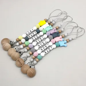 Silicone and beech wood baby pacifier clips set with crown charms in pastel colors