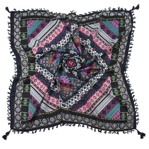 Close-up of bohemian geometric jacquard patterns and dark blue tassels on a soft scarf