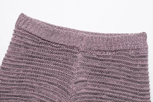 Detail of purple knitted shorts featuring hollow-out crochet texture and elastic ribbed waistband