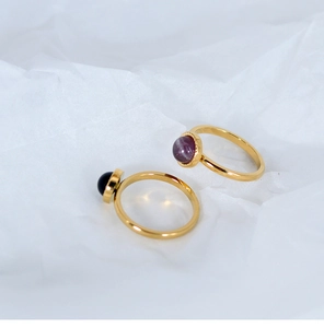 Detailed shot of gold plated titanium rings featuring amethyst and black gemstone beads
