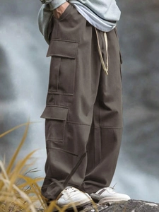 Scatto outdoor di pantaloni cargo marroni multitasche in uno scenario di montagna