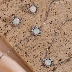 Silver stainless steel sun pendant necklace and earrings set with white opal center
