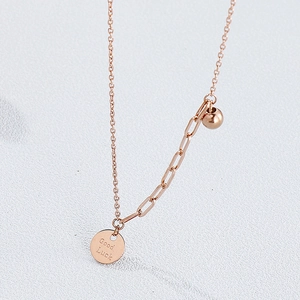 Detailed macro view of rose gold Good Luck circular pendant with asymmetrical chain link