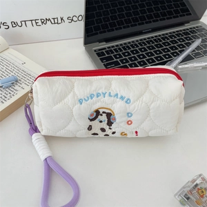 Macro view of the white quilted heart pattern pouch with cute puppy embroidery