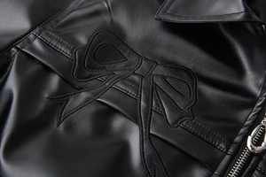 Vue détaillée de la veste noire en similicuir avec broderie nœud et fermeture éclair argent