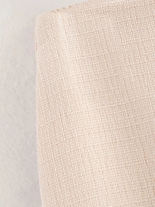 Close-up of the light beige textured woven fabric detail showing linen material quality
