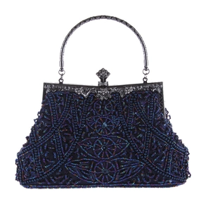 Dettaglio borsa da sera vintage con perline, motivi floreali blu e manico in metallo