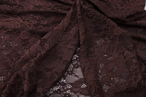 Detailed macro shot of dark brown lace fabric featuring intricate floral mesh patterns