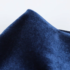 Detailed macro view of dark blue velvet fabric showing premium texture and soft luster