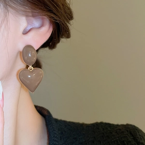 Close-up of elegant coffee-toned heart drop earrings with gold metal edges