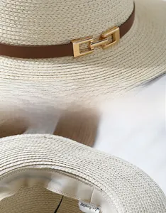 Detail of high-quality straw hat with brown leather strap and golden buckle buckle