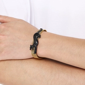 Detail shot of golden mesh strap bracelet with a glossy black cheetah leopard head charm