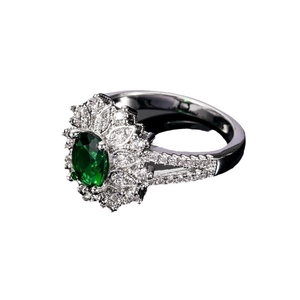 Silver halo ring featuring oval green emerald and shimmering clear zircon accents