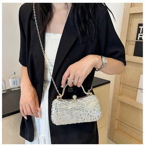 Close-up of silver sequin evening bag with crystal details and a chain strap