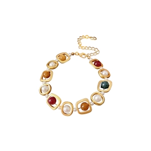 Vintage gold metal bracelet with colorful beads and white pearls in minimalist design