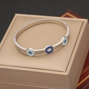 Polished silver stainless steel bangle with blue enamel floral circle charms